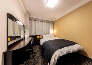 a hotel room with a bed and a sink at APA Hotel Kanazawa-nishi in Kanazawa