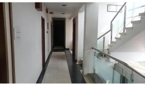 um corredor de um edifício com escadas e uma porta preta em FabHotel Skylark Inn em Nashik
