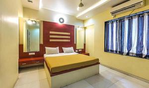 um quarto com uma cama, um espelho e janelas em FabHotel Skylark Inn em Nashik