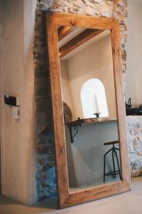 a mirror with a wooden frame in a room at Churchill Townhouse in Bodrum City