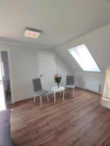 a room with two chairs and a table and a skylight at Apartamenti Bocmaņa laukums 2A, Salacgrīva in Salacgrīva