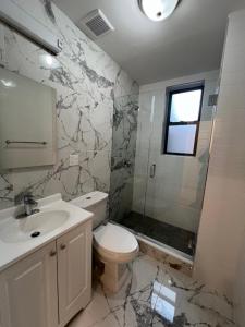 a bathroom with a toilet and a sink and a shower at Apartment in New York By Central Park in New York