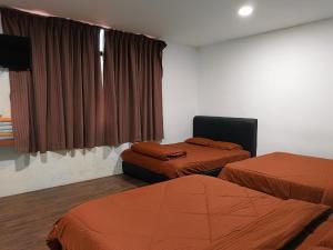 a hotel room with two beds and a television at BMW Hotel in Muar