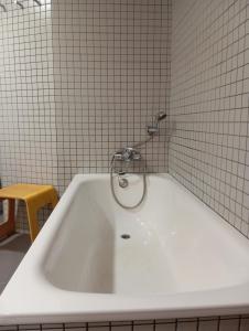 eine weiße Badewanne mit einem Wasserhahn im Bad in der Unterkunft Casa El Angel Loft Denia centro con parking in Denia + 35 Fotos