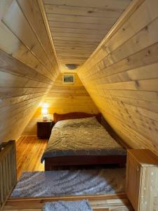 a room with a bed in a wooden attic at Vikendica sa bazenom MAGNUM in Višegrad +11 photos