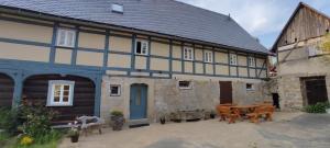 an old house with a table and chairs in front of it at Flachshäusl in Mittelndorf