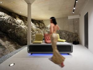 uma mulher a passar por uma cama num quarto em Haus Fünf mit 2 Apartments und Studio-Loft mit Terrasse em Melk