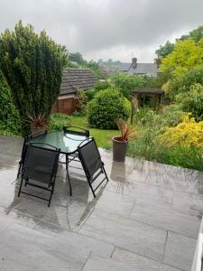 un tavolo in vetro e 2 sedie su un patio di Boutique bungalow a Haverhill