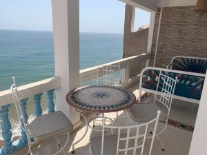 a balcony with a table and chairs and the ocean at Taghazout Waves 1 in Taghazout