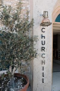 a potted tree in a pot next to a hotel sign at Churchill Townhouse in Bodrum City
