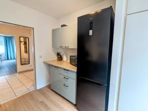a kitchen with a black refrigerator in a room at Monteur Atelier in Marl