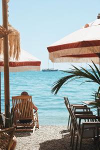 a person sitting in chairs on a beach with the ocean at Churchill Townhouse in Bodrum City