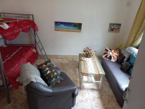 uma sala de estar com um sofá e uma mesa em Open Air Café & Apartment 1 em Port Louis
