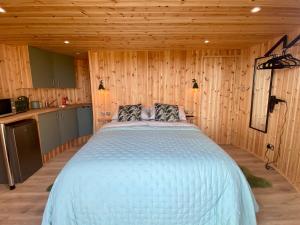 a bedroom with a bed in a wooden room at Silo Green in Great Dunmow