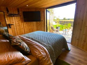a bedroom with a bed and a television on a wall at Silo Green in Great Dunmow