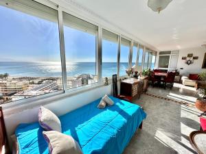 1 dormitorio con cama azul y vistas al océano en Playamar Paradise Sea Views, en Torremolinos