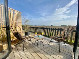 two chairs and a table on a wooden deck at Silo Green in Great Dunmow