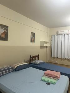 1 dormitorio con 2 camas y ventana en Hotel Centro, en Corumbá