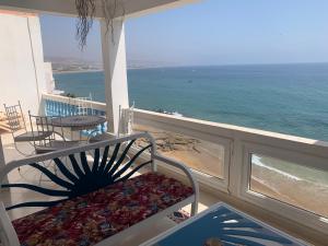 d'un balcon avec un banc et une vue sur l'océan. dans l'établissement Taghazout Waves 1, à Taghazout