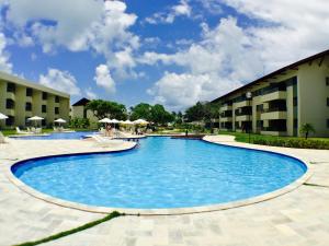 een groot zwembad naast een gebouw bij Carneiros Beach Resort in Praia dos Carneiros
