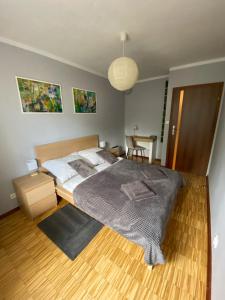 a bedroom with a large bed and a wooden floor at Apartament Mosiężna & Taras & Free Parking & Self Check in 24H in Wrocław