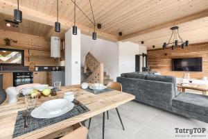 salon ze stołem i kanapą w obiekcie Czarne Wierchy jacuzzi - Luxury Chalets Kościelisko w mieście Kościelisko
