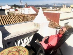 eine Frau auf einem Stuhl auf einem Balkon in der Unterkunft Cute and characterful townhouse in Oliva