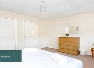 a white bedroom with a bed and a dresser at Clarence Suite - Free Parking in Chatham