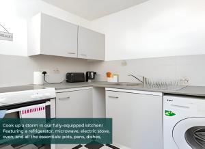 a kitchen with white cabinets and a washer and dryer at Clarence Suite - Free Parking in Chatham