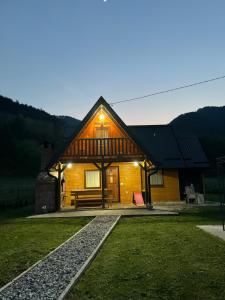 a wooden cabin with a bench in front of it at Vikendica sa bazenom MAGNUM in Višegrad