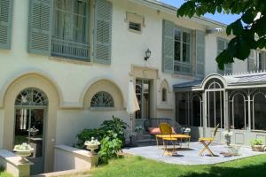 a house with chairs and a table in the yard at Les Gargouilles - House with crazy charm heated pool and garden in Caluire-et-Cuire