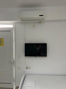 a room with a flat screen tv on a wall at Guesthouse Butrinti in Ksamil