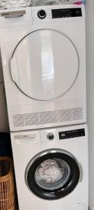 a white washer and dryer with its door open at Beach Front Apartment in Netanya