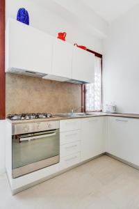 a kitchen with white cabinets and a stove at Ca' Derai in Venice