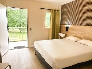 - une chambre avec un grand lit et une grande fenêtre dans l'établissement Hôtel Ecochic, Mont-de-Marsan Sud, à Saint-Pierre-du-Mont