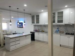 a large kitchen with white cabinets and a counter top at Pinto’s in Praia