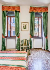 a bedroom with two beds and two windows at Ca' Derai in Venice
