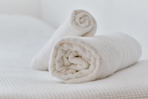 un rotolo di asciugamani bianchi appoggiato su un letto di Studio-Apartment Piccolino 26 a Timmendorfer Strand
