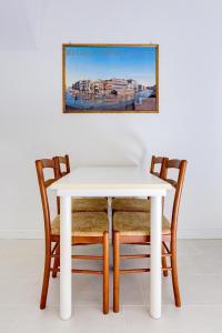 een witte tafel en stoelen met een foto aan de muur bij Ca' Derai in Venetië