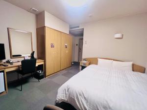 een hotelkamer met een bed, een bureau en een computer bij Dormy Inn Express Sendai Hirose Dori in Sendai