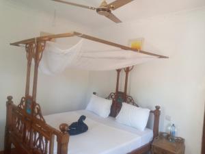 a bedroom with a bed with a canopy at Usumba Lodge 