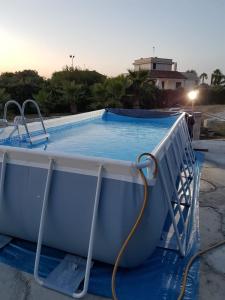 una piscina con una manguera. en Momon1616 Intero Chalet, en Galatina