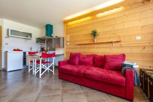 een woonkamer met een rode bank en een keuken bij Résidence Grands Montets 133 ski in-ski out - Happy Rentals in Chamonix-Mont-Blanc