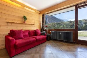 een rode bank in een kamer met een groot raam bij Résidence Grands Montets 133 ski in-ski out - Happy Rentals in Chamonix-Mont-Blanc