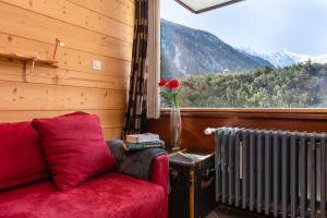 een woonkamer met een rode bank en een raam bij Résidence Grands Montets 133 ski in-ski out - Happy Rentals in Chamonix-Mont-Blanc