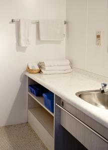 ein Badezimmer mit einem Waschbecken und einer Theke mit Handtüchern in der Unterkunft Apple Motor Inn in Hastings