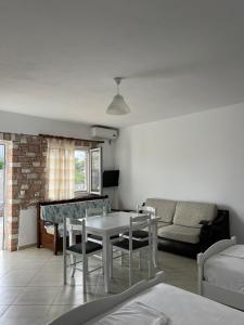 a living room with a table and a couch at Guesthouse Butrinti in Ksamil