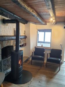 a living room with a fireplace and two chairs at Casa Grande in Falmenta +16 photos