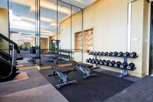 a gym with rows of exercise equipment and mirrors at JW Marriott Hotel Taiyuan in Taiyuan
