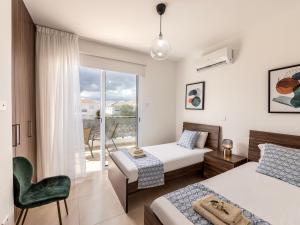 a bedroom with two beds and a balcony at Mythical Resort by KARMA in Paralimni +221 photos
